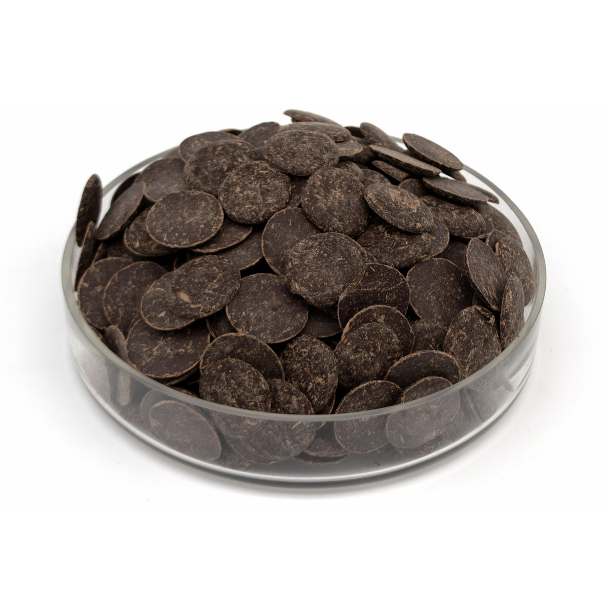 Dark chocolate wafers piled in a clear glass dish on a white background.