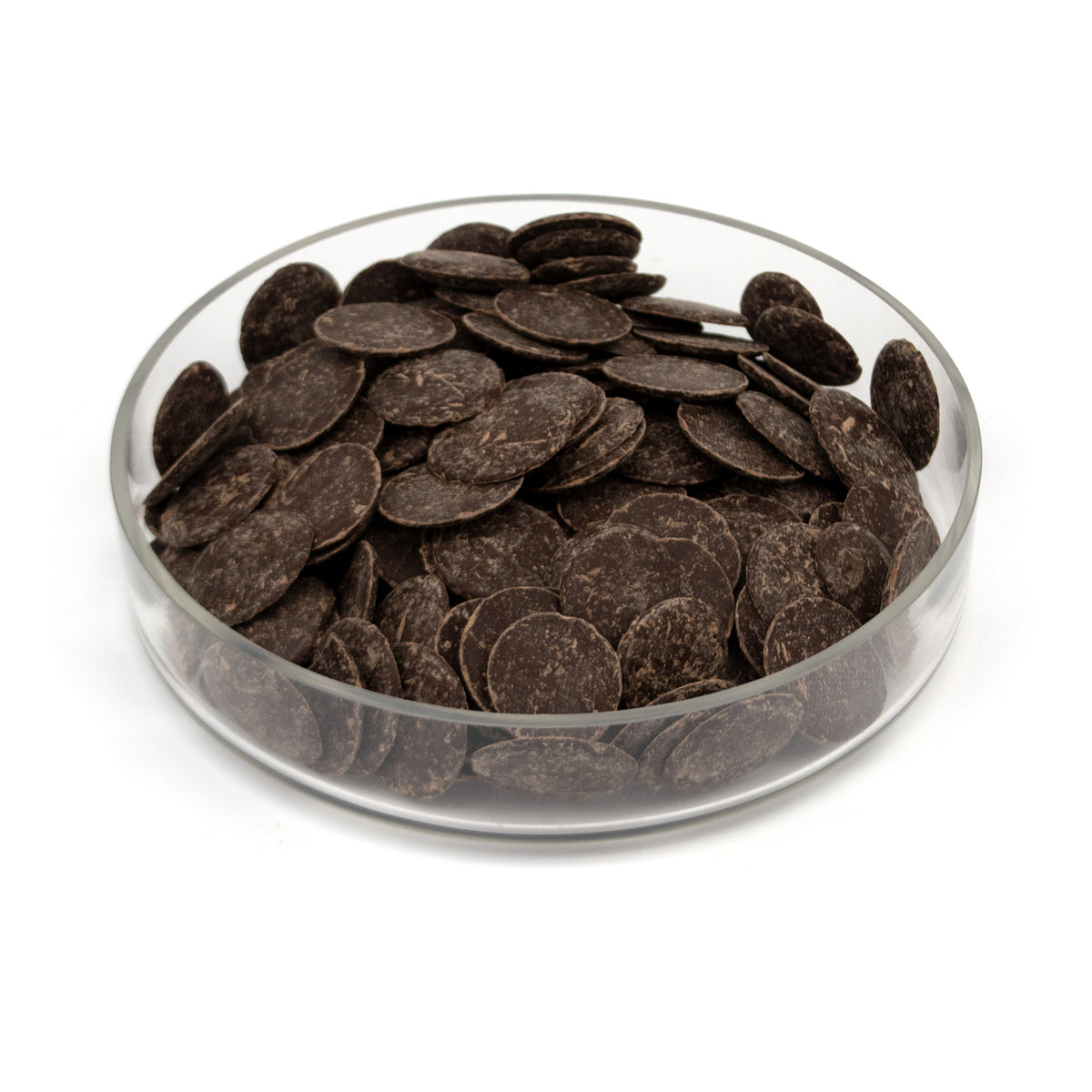 Dark chocolate wafers piled in a clear glass bowl on a white background.