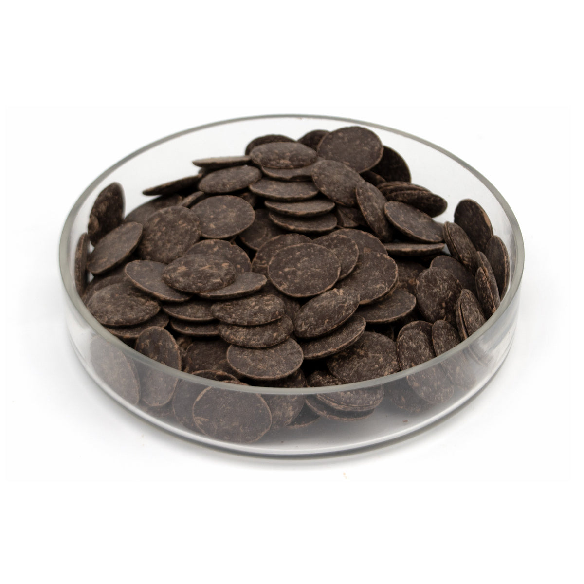Dark brown chocolate wafers piled in a clear glass bowl on a white background.