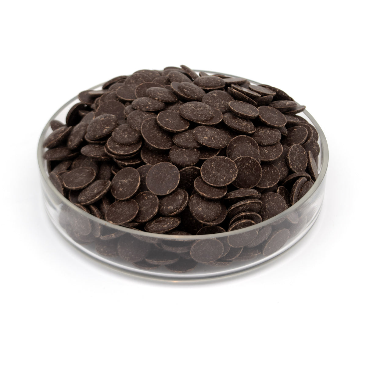 Dark chocolate wafers piled in a clear glass bowl on a white background.