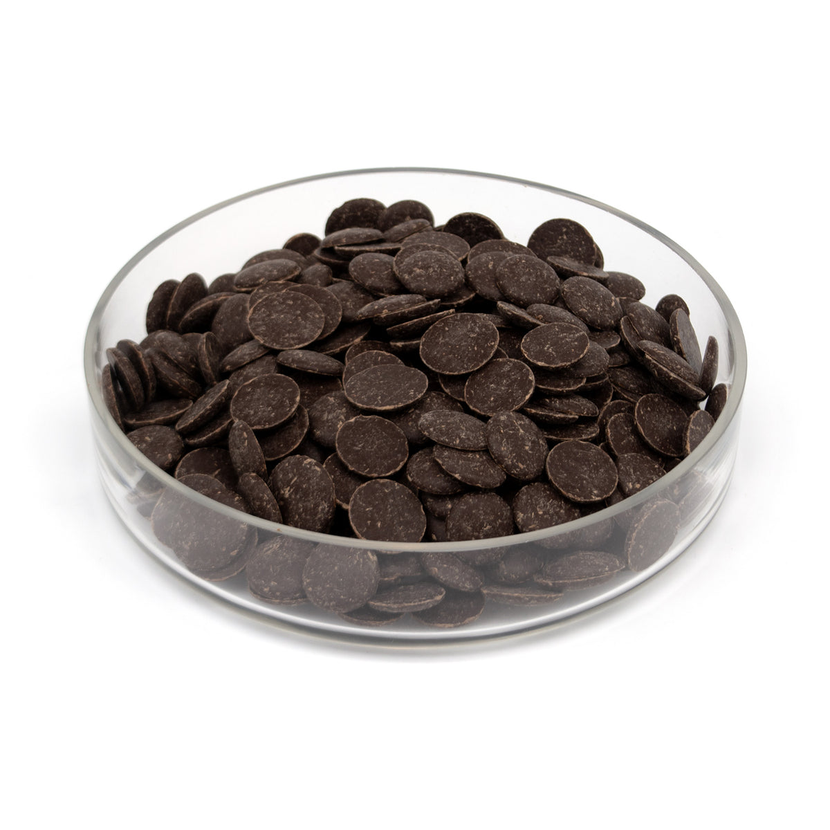 Dark chocolate wafers piled in a clear glass bowl on a white background.