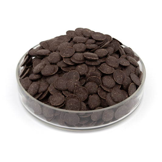 A pile of dark brown chocolate wafers in a clear round glass container, photographed on a white background.