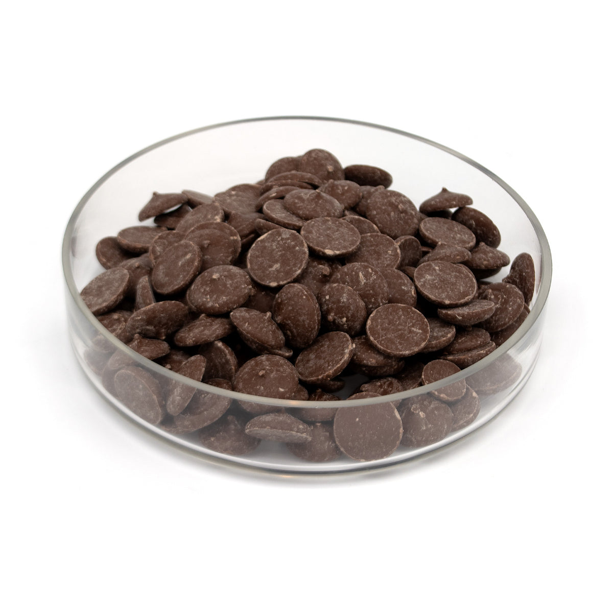 A pile of dark chocolate wafers in a glass bowl photographed on a white background