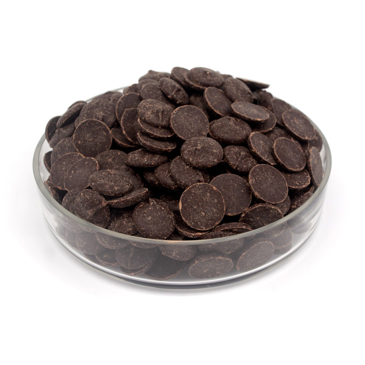 Dark chocolate wafers piled in a clear glass bowl on a white background.