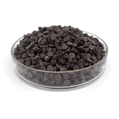 Glass bowl filled with dark chocolate chips on a white background