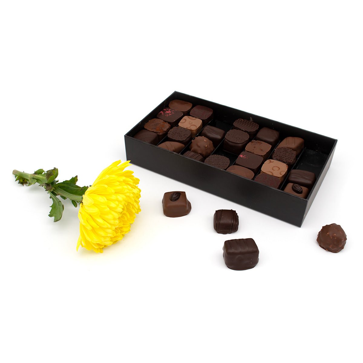 Box of chocolates with a yellow flower on a white background