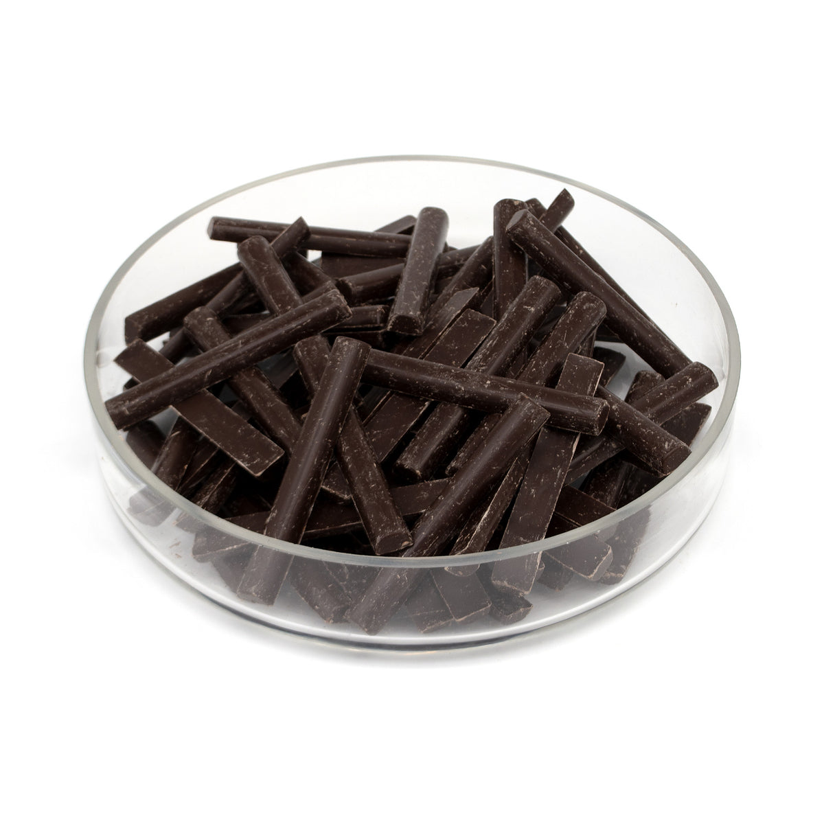 Dark chocolate batons piled in a clear glass bowl on a white background.