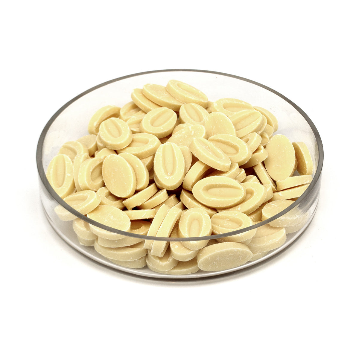 A clear round glass dish filled with small oval cream-colored chocolate discs, photographed on a plain white background.