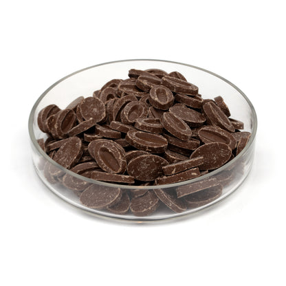 Chocolate feves in a clear glass bowl, photographed on a clean white background.