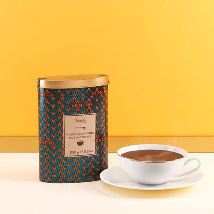Venchi hot chocolate canister with a cup of hot chocolate on a yellow background