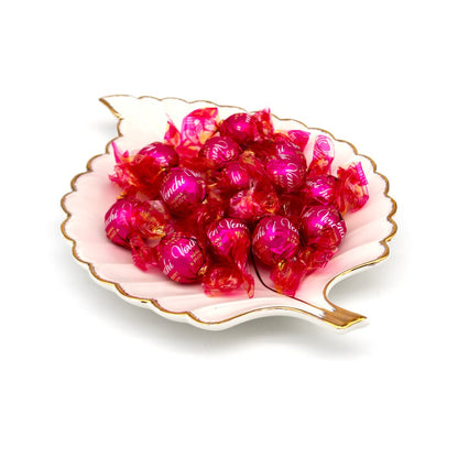 15 pink wrapped candies in a decorative dish